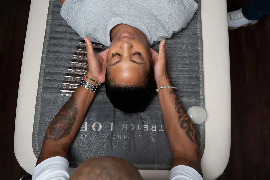 Client lying on the table, eyes closed, as the practitioner guides her breathing