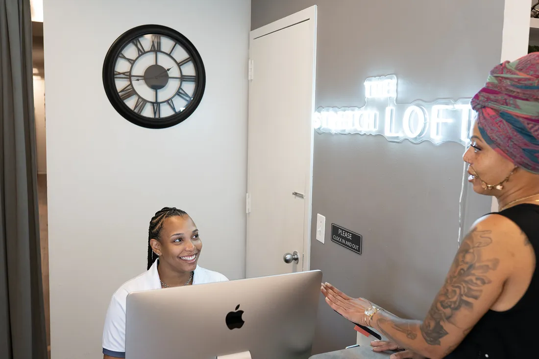 The Stretch Loft front desk with the illuminated wordmark on the wall